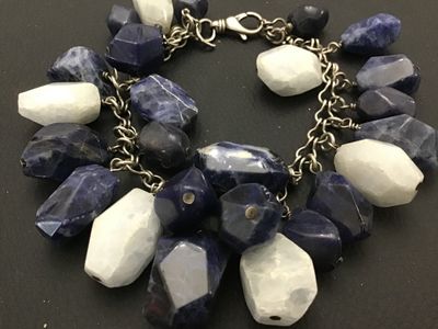 Sale Photo Thumbnail #150: A striking  925 chunky charm-style bracelet featuring large, faceted natural stone beads in shades of deep blue sodalite and white quartz or moonstone. The stones are attached to a silver-tone chain with a lobster claw clasp. The clasp appears to have fai