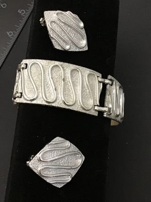 Sale Photo Thumbnail #191: Vintage Sarah Coventry silver-tone costume jewelry set featuring a panel link bracelet and matching diamond-shaped clip-on earrings with a textured surface and raised swirl design. The bracelet measures approximately 7.25 inches long. Signed 'SARAH COV' o