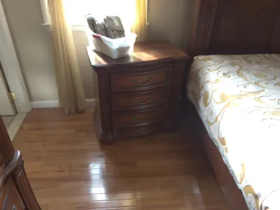 Sale Photo Thumbnail #27: Traditional dark wood three-drawer nightstand with ornate bronze-tone hardware, paired next to a matching bed frame.