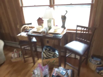 Sale Photo Thumbnail #5: Dark wood pub table set with two matching padded chairs, accompanied by table decor, a lamp, and various storage baskets.