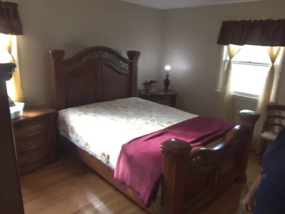 Sale Photo Thumbnail #22: Traditional dark wood queen-size bedroom suite including a carved headboard and footboard frame, paired with matching nightstands.