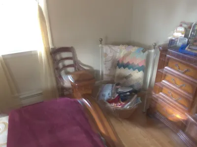 Sale Photo Thumbnail #26: Bedroom set including a wooden sleigh bed frame, traditional wooden dresser with decorative bail handles, ladder-back side chair, and a freestanding blanket rack displaying quilts.