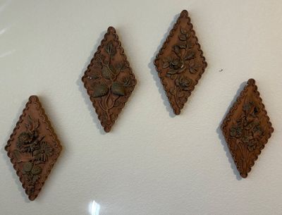 Set of four vintage Syroco-style diamond-shaped wall plaques featuring molded floral and botanical motifs.
