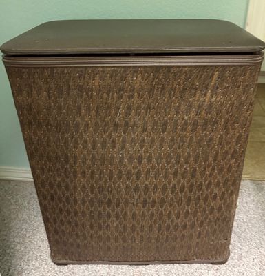 Vintage brown woven hamper with a padded vinyl lid, showing minor surface wear.