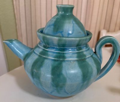 Vintage ceramic teapot featuring a light blue and turquoise drip glaze with a matching lid.