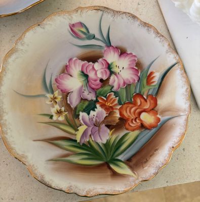 Hand-painted porcelain display plate featuring a vibrant floral bouquet and a gilded scalloped rim, signed by artist Tokunaga.