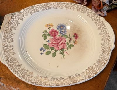 Vintage ceramic serving platter with a floral bouquet center motif and gold filigree border trim.