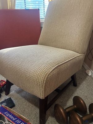 Armless slipper chair upholstered in a neutral textured corduroy fabric, resting on dark wooden legs.