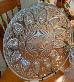 Vintage clear pressed cut glass serving platter with a sunburst center and teardrop rim pattern.