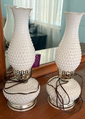 Pair of vintage Fenton-style white hobnail milk glass vanity table lamps with ruffled chimneys and metal bases.