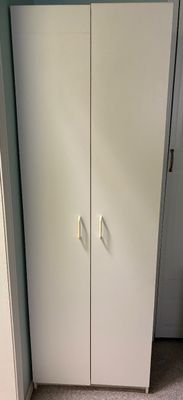 Tall contemporary white double-door storage cabinet featuring simple white handles and a minimalist design.