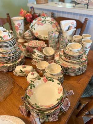 Large vintage Franciscian Desert Rose dinnerware service displayed on a wooden dining table, including plates, bowls, teacups, pitchers,...
