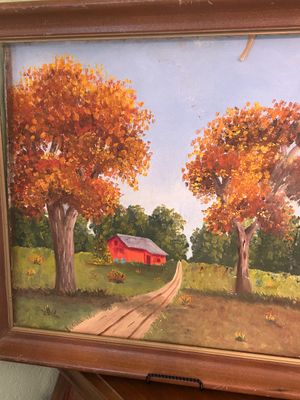 Framed autumn landscape oil painting featuring autumn trees, a dirt path, and a red barn, housed in a molded wooden frame.
