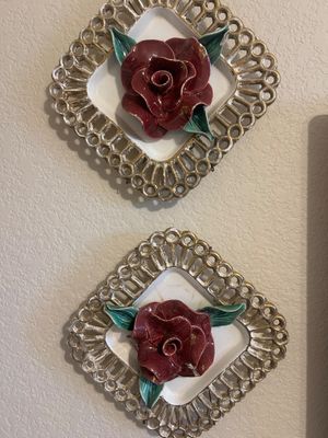 Pair of vintage ceramic rose wall plaques featuring dimensional red roses framed by reticulated, gilded diamond-shaped borders.