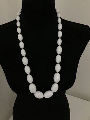 Sale Photo Thumbnail #264: A classic strand necklace featuring smooth, glossy white oval beads spaced with small gold-tone seed beads. Secured with a traditional gold-tone spring ring clasp. Appears to be in good vintage condition with minimal surface wear.