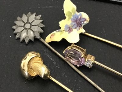 Sale Photo Thumbnail #123: Collection of four vintage stick pins featuring a variety of designs including an enameled floral butterfly, a gold-tone mushroom, a flower motif, and a pin set with a faceted purple stone (possibly amethyst or glass) and accent stone. Includes end caps o