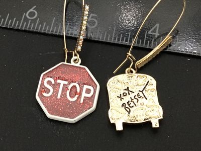 Sale Photo Thumbnail #129: Pair of Betsey Johnson mismatched drop/dangle wire earrings featuring a yellow enamel school bus with rhinestone accents on one side and a red glitter enamel stop sign on the other. Signed 'xox Betsey' on the back. Features gold-tone long French wire ear 