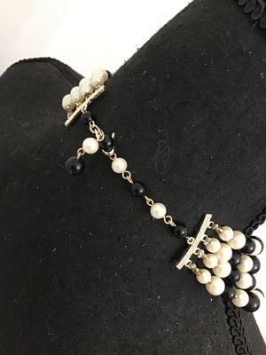 Sale Photo Thumbnail #70: A classic vintage multi-strand choker necklace featuring alternating rows of faux cream pearls with metal bead caps and polished black accent beads. Gold-tone chain extension and multi-strand spacer bars allow for adjustable sizing. Features nice luster a