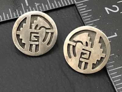 Sale Photo Thumbnail #174: A pair of round sterling silver stud earrings featuring a cut-out overlay design in a Southwestern / Hopi style geometric motif with textured recessed background. Measure approximately 3/4 inches in diameter. Minor surface wear and natural patina appropri