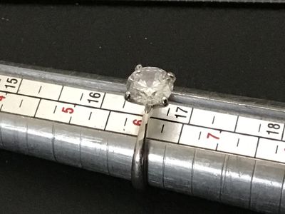 Sale Photo Thumbnail #221: A sterling silver solitaire ring featuring a large round brilliant cut clear stone (likely cubic zirconia or simulated diamond) in a four-prong setting. The interior band is stamped "S925". Shown on a ring mandrel as a size 6. In good pre-owned condition 
