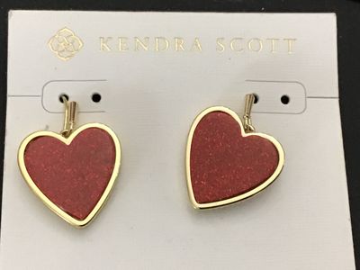 Sale Photo Thumbnail #134: Pair of Kendra Scott gold-tone drop earrings featuring red heart-shaped stones/inlays. On original brand display card with backings included. Original price tag showing $110.00 on back. New with tags condition with no visible damage or signs of wear.