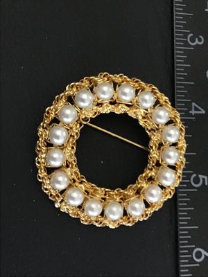 Sale Photo Thumbnail #29: A vintage gold-tone circle/wreath brooch by Hobe featuring faux pearls set within an intricate braided chain border. Signed 'Hobe' on an oval plaque on the reverse. Measures approximately 1.75 inches in diameter. Secure pin back closure with safety clasp.