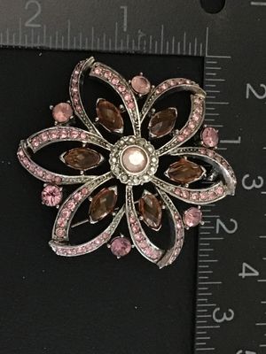 Sale Photo Thumbnail #33: Silver-tone floral pin or brooch set with light pink and amber marquise-cut and round rhinestones. Measures approximately 2.25 inches across. Features a textured back and pin-back clasp mechanism. Good pre-owned condition with all stones intact.