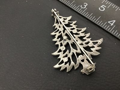 Sale Photo Thumbnail #53: Vintage Christmas tree brooch pin marked '©JJ' (Jonette Jewelry Co.) on the back. Features pewter-tone and gold-tone layered branches adorned with colorful red, green, and yellow rhinestone ornaments and a star topper. Measures approximately 2.25 inches 