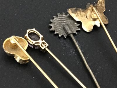 Sale Photo Thumbnail #124: Collection of four vintage stick pins featuring a variety of designs including an enameled floral butterfly, a gold-tone mushroom, a flower motif, and a pin set with a faceted purple stone (possibly amethyst or glass) and accent stone. Includes end caps o