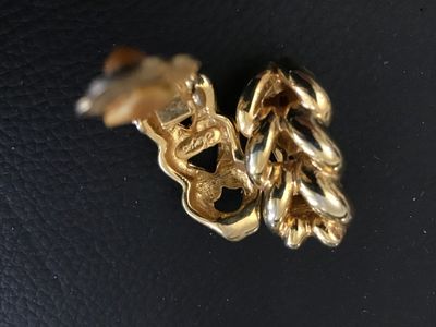 Sale Photo Thumbnail #78: A pair of vintage Keyes gold-tone clip-on earrings featuring a chunky twisted chain link design. Marked 'Keyes' on the reverse side of both earrings. Includes original comfort cushions on the clip mechanisms. Measure approximately 1 inch in length. In goo