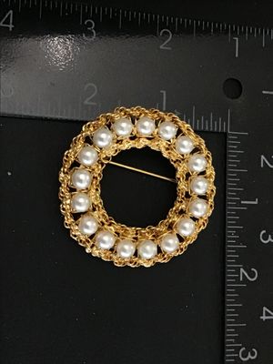 Sale Photo Thumbnail #30: A vintage gold-tone circle/wreath brooch by Hobe featuring faux pearls set within an intricate braided chain border. Signed 'Hobe' on an oval plaque on the reverse. Measures approximately 1.75 inches in diameter. Secure pin back closure with safety clasp.