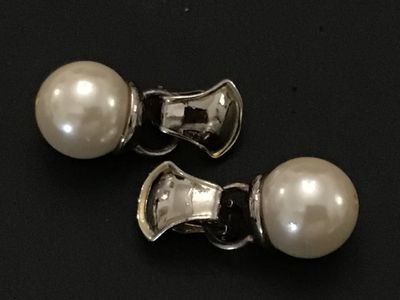 Sale Photo Thumbnail #186: Pair of silver-tone clip-on earrings featuring round faux pearl dangles. Includes curved clip backs. . Measures approximately 1 inch in length overall. Silver-tone metal with simulated pearls.