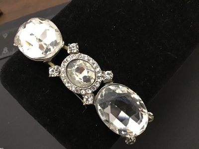 Sale Photo Thumbnail #274: Faceted clear glass/rhinestone stretch bracelet featuring alternating large oval faceted stones and halo-set center stones with small accent rhinestones in silver-tone metal settings. Elasticized stretch band construction. Shows minor age-appropriate wear