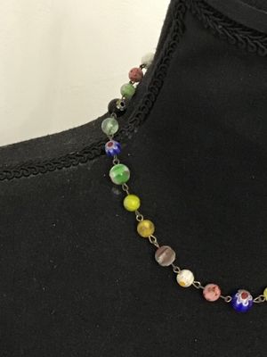 Sale Photo Thumbnail #119: A colorful vintage necklace featuring handcrafted Venetian Murano Millefiori art glass beads in various floral and patterned designs, connected by brass tone metal wire link loops. Includes a variety of vibrant glass beads in shades of blue, yellow, green