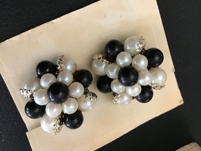 Sale Photo Thumbnail #71: Pair of vintage cluster clip-on earrings featuring a mix of black and white faux pearls in gold-tone metal filigree settings. Mounted on original display card stamped 'MADE IN JAPAN'. Clips are intact and functional. Minor age-appropriate wear visible.
