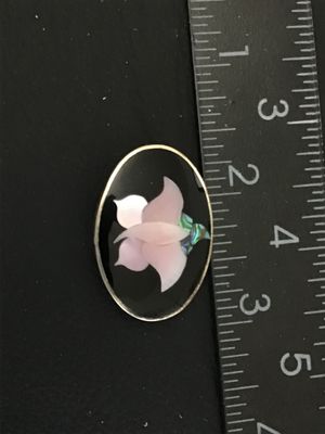 Sale Photo Thumbnail #31: Vintage oval-shaped brooch pin/pendant featuring a mother-of-pearl and abalone shell floral inlay on a black background. The back is marked "Designed in Vermont U.S.A. © Ana Lilia Made in Mexico Handmade". Measures approximately 1.5 inches in length. Fea