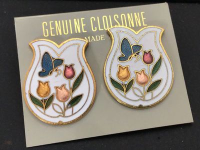 Sale Photo Thumbnail #202: Pair of vintage cloisonne post earrings featuring a tulip vase motif with colorful tulips and blue butterflies on a white background with gold-tone accents. Mounted on original display card marked 'Genuine Cloisonne'. Pierced stud style backings.
