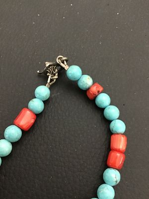 Sale Photo Thumbnail #6: Unique beaded strand necklace featuring turquoise-colored and red coral-tone beads interspersed with blown/cast glass horse head charms. Features a focal drop with a glass horse head, large red bead, and a stamped metal cross pendant. Includes a metal tog