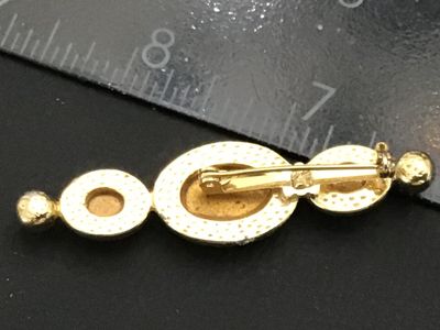 Sale Photo Thumbnail #244: A vintage gold tone bar brooch featuring three oval-cut blue glass rhinestones in varying shades of aqua, light blue, and deep sapphire blue, flanked by two small faux pearls at either end. The pin features a textured back with a standard safety bar clasp