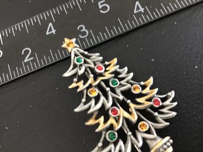 Sale Photo Thumbnail #51: Vintage Christmas tree brooch pin marked '©JJ' (Jonette Jewelry Co.) on the back. Features pewter-tone and gold-tone layered branches adorned with colorful red, green, and yellow rhinestone ornaments and a star topper. Measures approximately 2.25 inches 