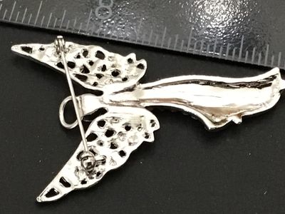 Sale Photo Thumbnail #224: Silver-tone metal brooch designed in the shape of a winged guardian angel with a halo, densely set with clear rhinestones throughout the body and openwork wings. Features a standard pin back with rollover safety clasp. Measures approximately 2.25 inches i
