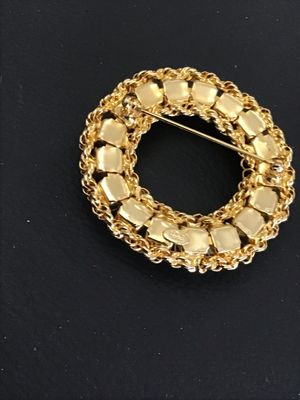 Sale Photo Thumbnail #28: A vintage gold-tone circle/wreath brooch by Hobe featuring faux pearls set within an intricate braided chain border. Signed 'Hobe' on an oval plaque on the reverse. Measures approximately 1.75 inches in diameter. Secure pin back closure with safety clasp.