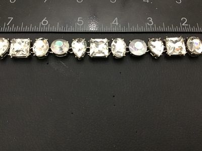 Sale Photo Thumbnail #279: A vintage costume jewelry link bracelet featuring an alternating sequence of multi-cut clear glass rhinestones and iridescent aurora borealis (AB) round stones in silver-tone prong settings. Includes pear-cut, square, oval, and round stones. Measures appr