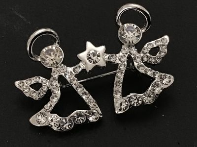 Sale Photo Thumbnail #90: Silver-tone costume jewelry pin/brooch featuring two winged angels holding a central star, fully encrusted with clear, faceted rhinestones. Fitted with a rollover safety clasp on the back. Measures approximately 2 inches wide. Excellent condition with all
