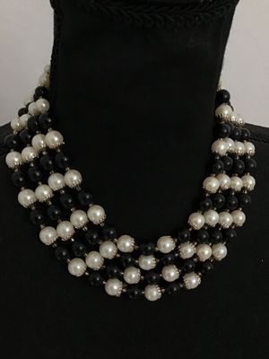 Sale Photo Thumbnail #67: A classic vintage multi-strand choker necklace featuring alternating rows of faux cream pearls with metal bead caps and polished black accent beads. Gold-tone chain extension and multi-strand spacer bars allow for adjustable sizing. Features nice luster a