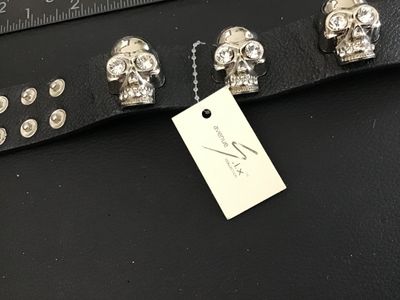 Sale Photo Thumbnail #56: Avenue Six Collection black textured leather or faux-leather cuff bracelet featuring three silver-tone metallic skulls set with clear rhinestone eyes and teeth accents. Secured with double snap closure. Measures approximately 8.5 to 9 inches long total. I
