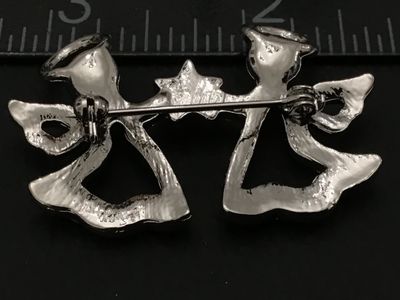 Sale Photo Thumbnail #91: Silver-tone costume jewelry pin/brooch featuring two winged angels holding a central star, fully encrusted with clear, faceted rhinestones. Fitted with a rollover safety clasp on the back. Measures approximately 2 inches wide. Excellent condition with all