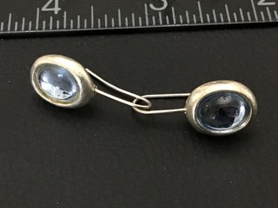 Sale Photo Thumbnail #192: Pair of wire hook drop earrings featuring oval light blue glass cabochons set in silver-tone bezels with textured backs. In good pre-owned condition with slight surface wear.
