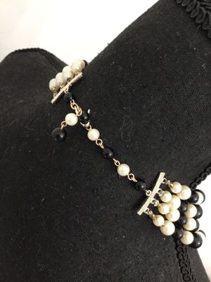 Sale Photo Thumbnail #68: A classic vintage multi-strand choker necklace featuring alternating rows of faux cream pearls with metal bead caps and polished black accent beads. Gold-tone chain extension and multi-strand spacer bars allow for adjustable sizing. Features nice luster a