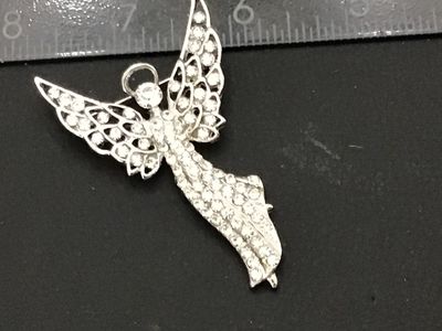 Sale Photo Thumbnail #228: Silver-tone metal brooch designed in the shape of a winged guardian angel with a halo, densely set with clear rhinestones throughout the body and openwork wings. Features a standard pin back with rollover safety clasp. Measures approximately 2.25 inches i
